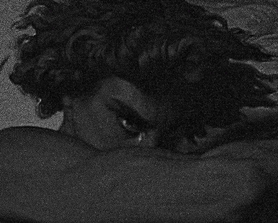 Grainy monochrome portrait resting in shadow